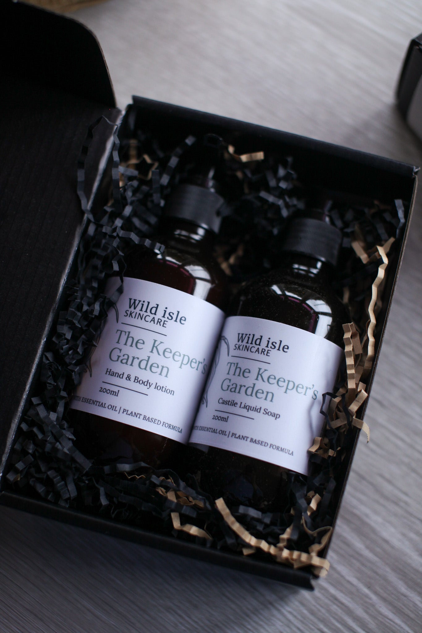 Two bottles of 'The Keeper's Garden' by Wild Isle Botanicals in a black gift box.