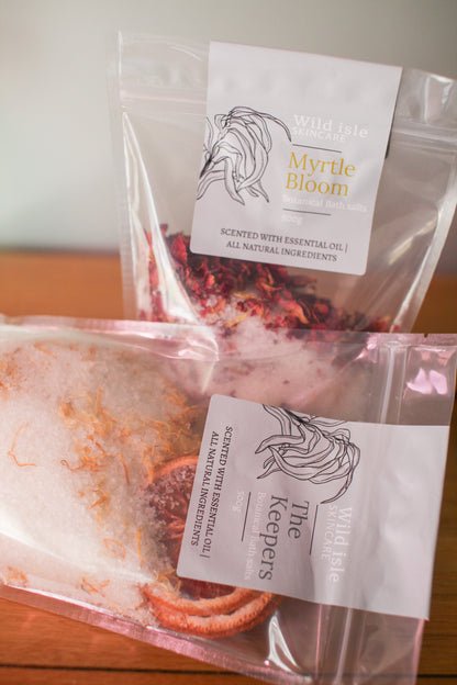 Two packages of 'Myrtle Bloom' by 'The Keepers' on a wooden surface.